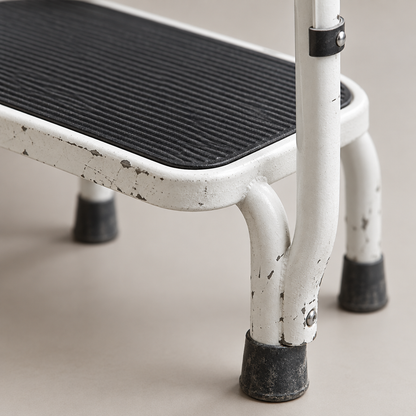Close-up detail of step stool non-slip tread and support handle